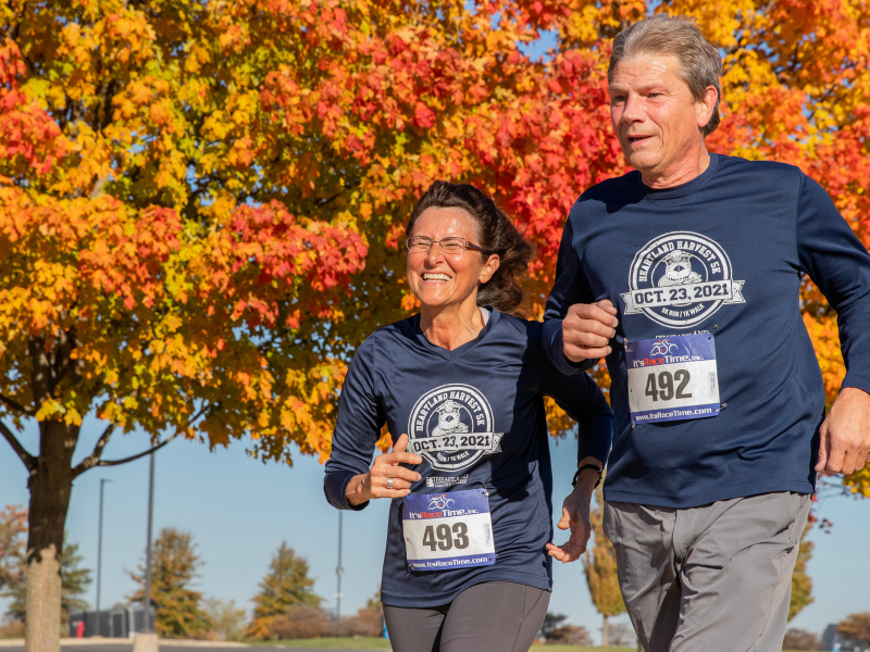 Image of two runners against a fall tree background