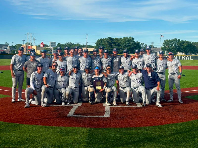A photo of the baseball team posing for a group photo on the baseball field