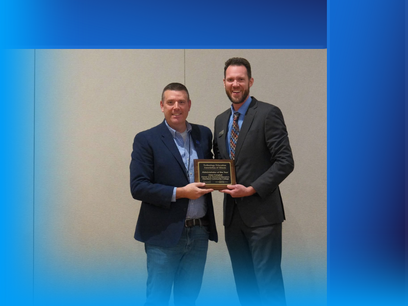 A photo of Adam Campbell getting presented with an award from another man