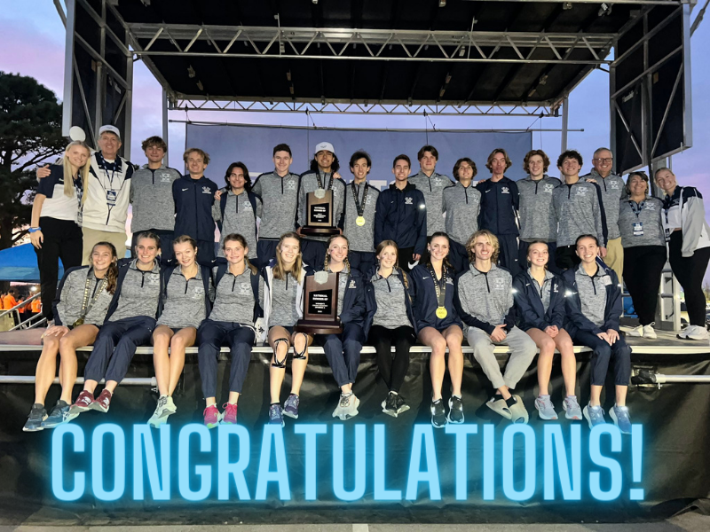 A picture of the men's and women's cross country teams sitting on a stage holding awards