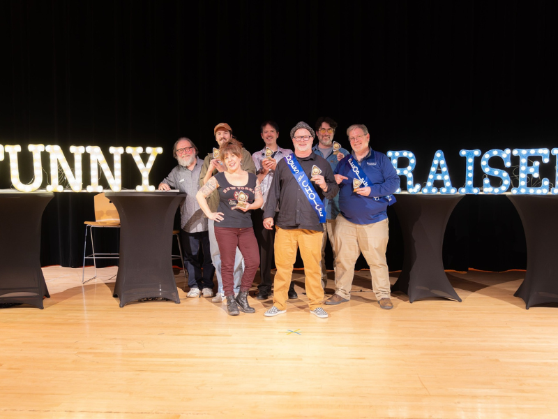 A photo people on a stage with the word FunnyRaiser