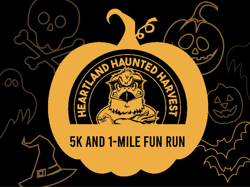 An image of Hunter in a pumpkin with the words Heartland Harvest 5K and 1K fun run. Bats, witches hat, ghosts, skull and crossbones and jack-o-lanterns in the background