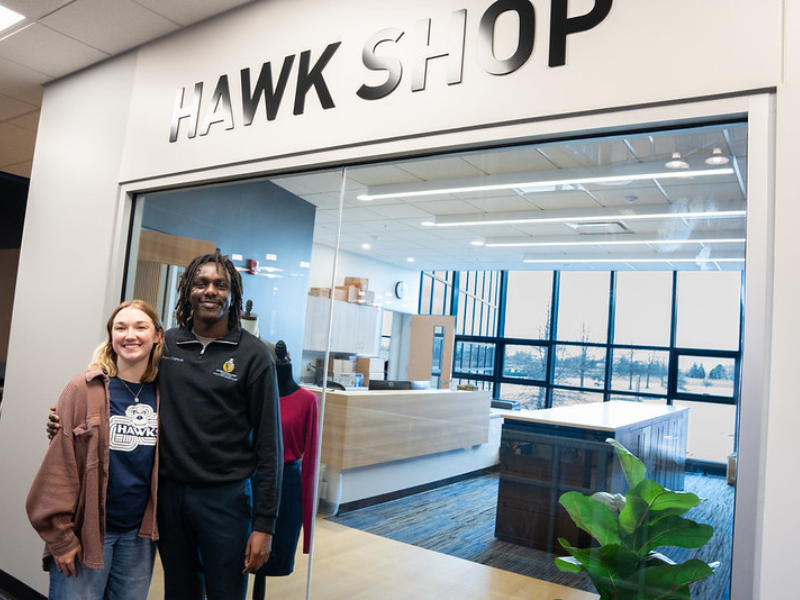 two students in front of the Hawk Shop