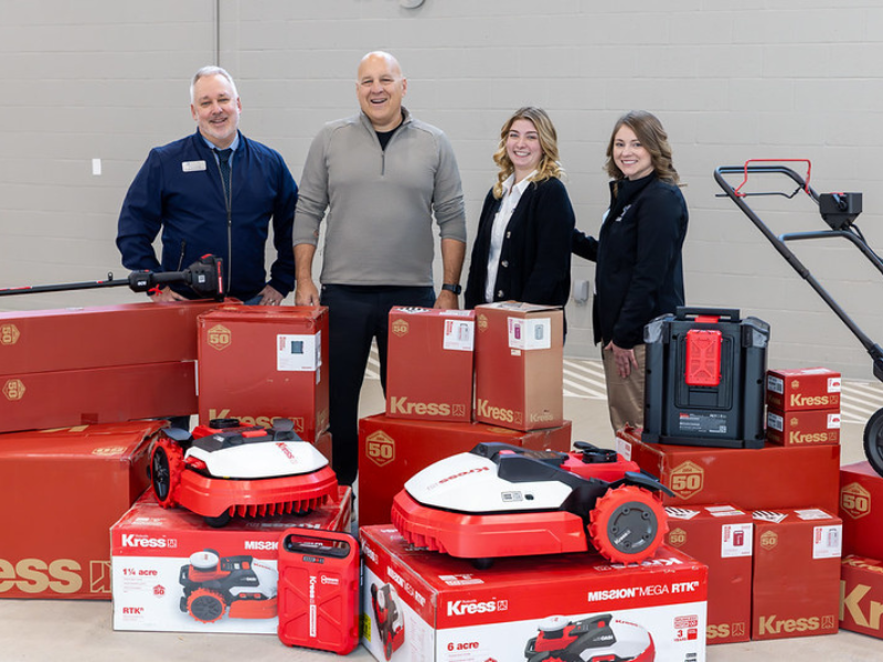A photo of a group of people and a selection of Kress landscaping machinery