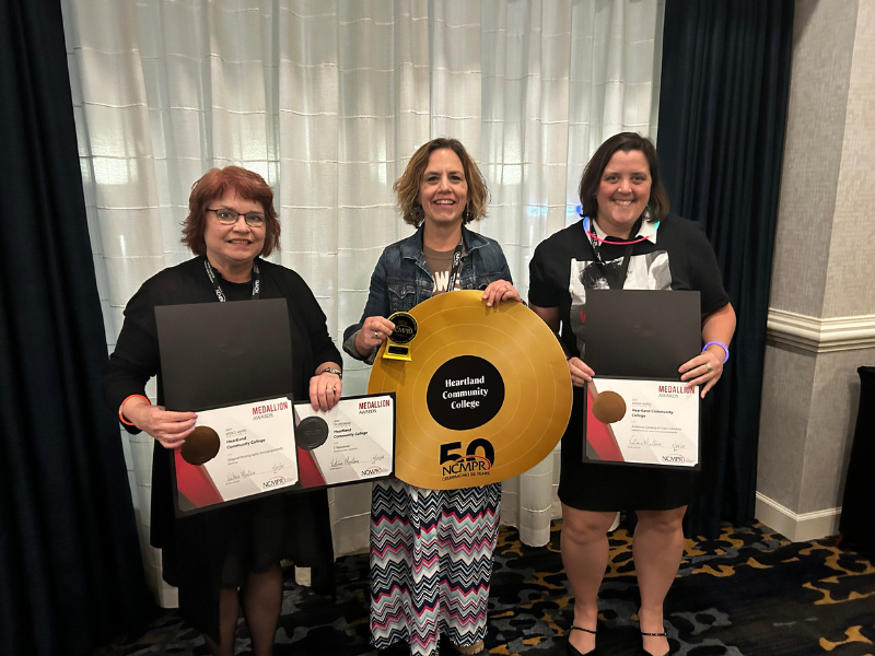 A picture of a group of 3 women holding awards