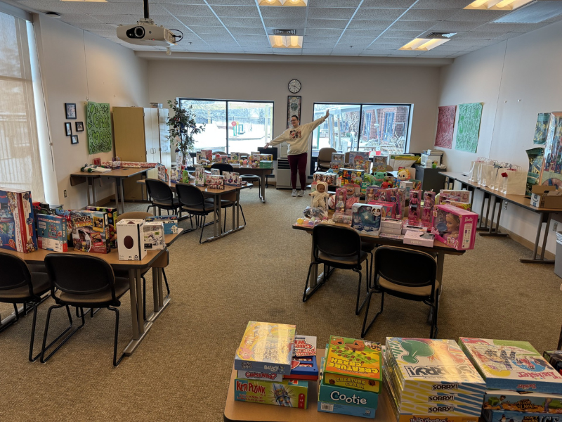 A photo of a room full of toys and a woman showing them off