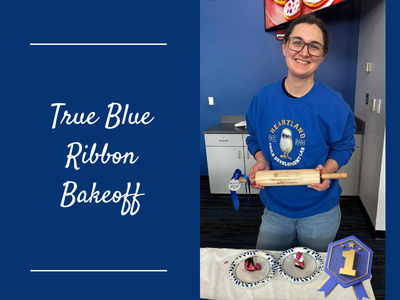 A photo of a woman holding a rolling pin standing behind baked goods