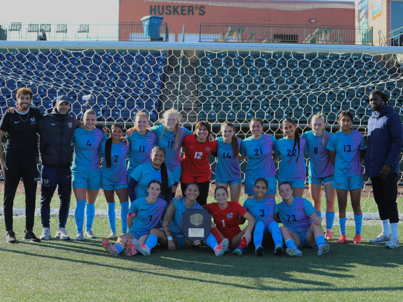 A photo of the women's soccer team with their 2nd place plaque