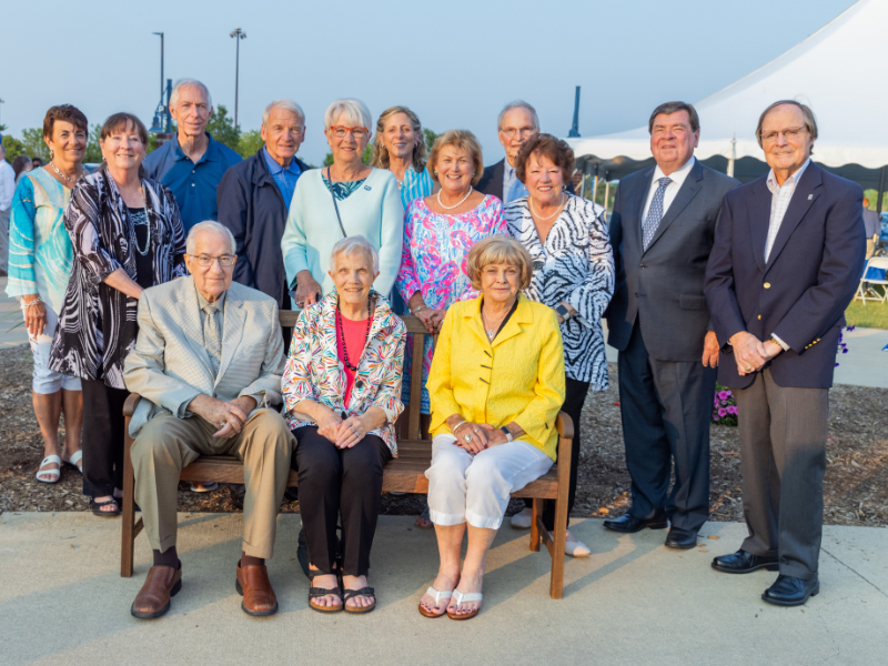 A group of people standing and sitting 